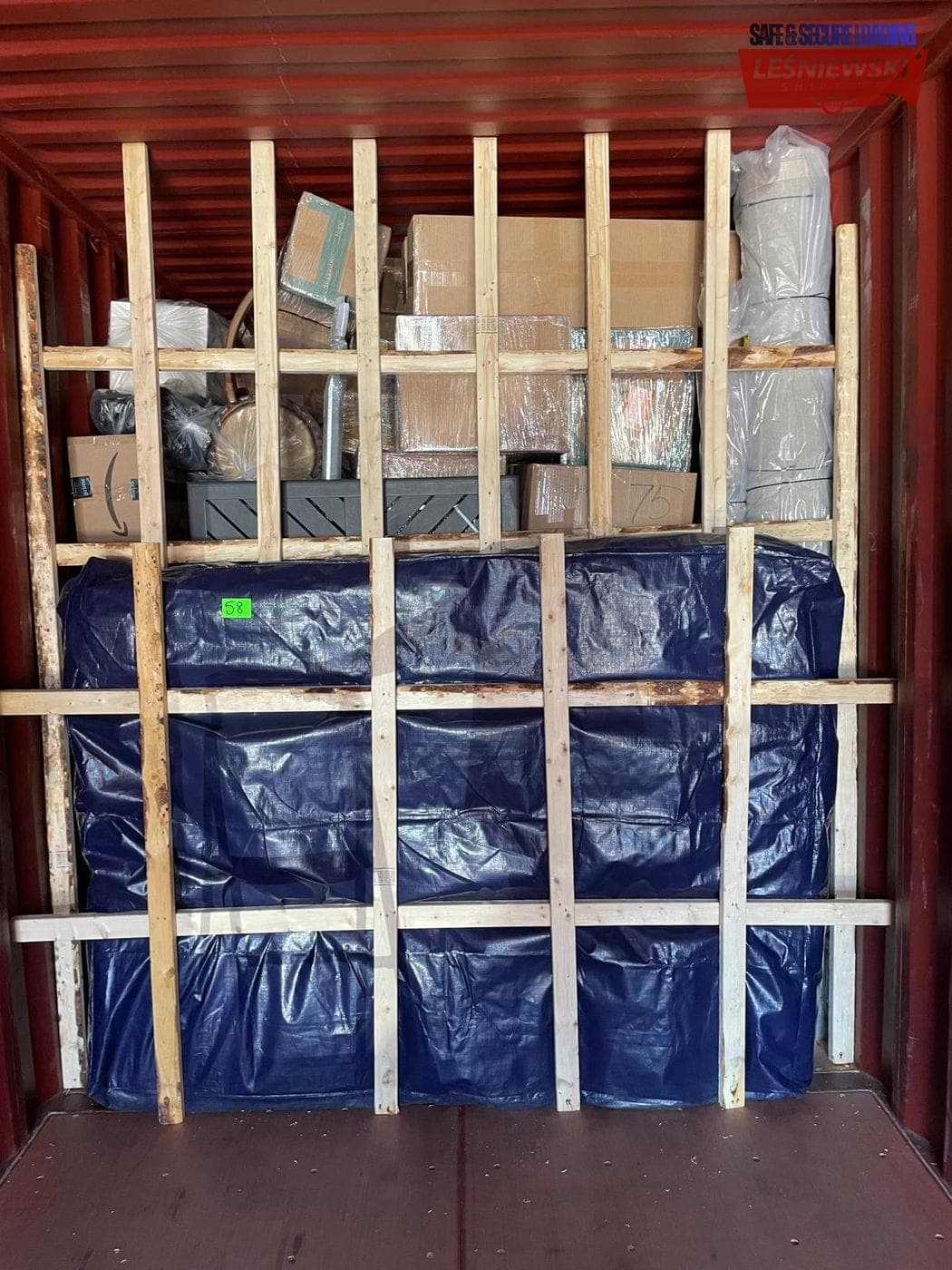 Household goods in a container — furniture under a tarp and boxes