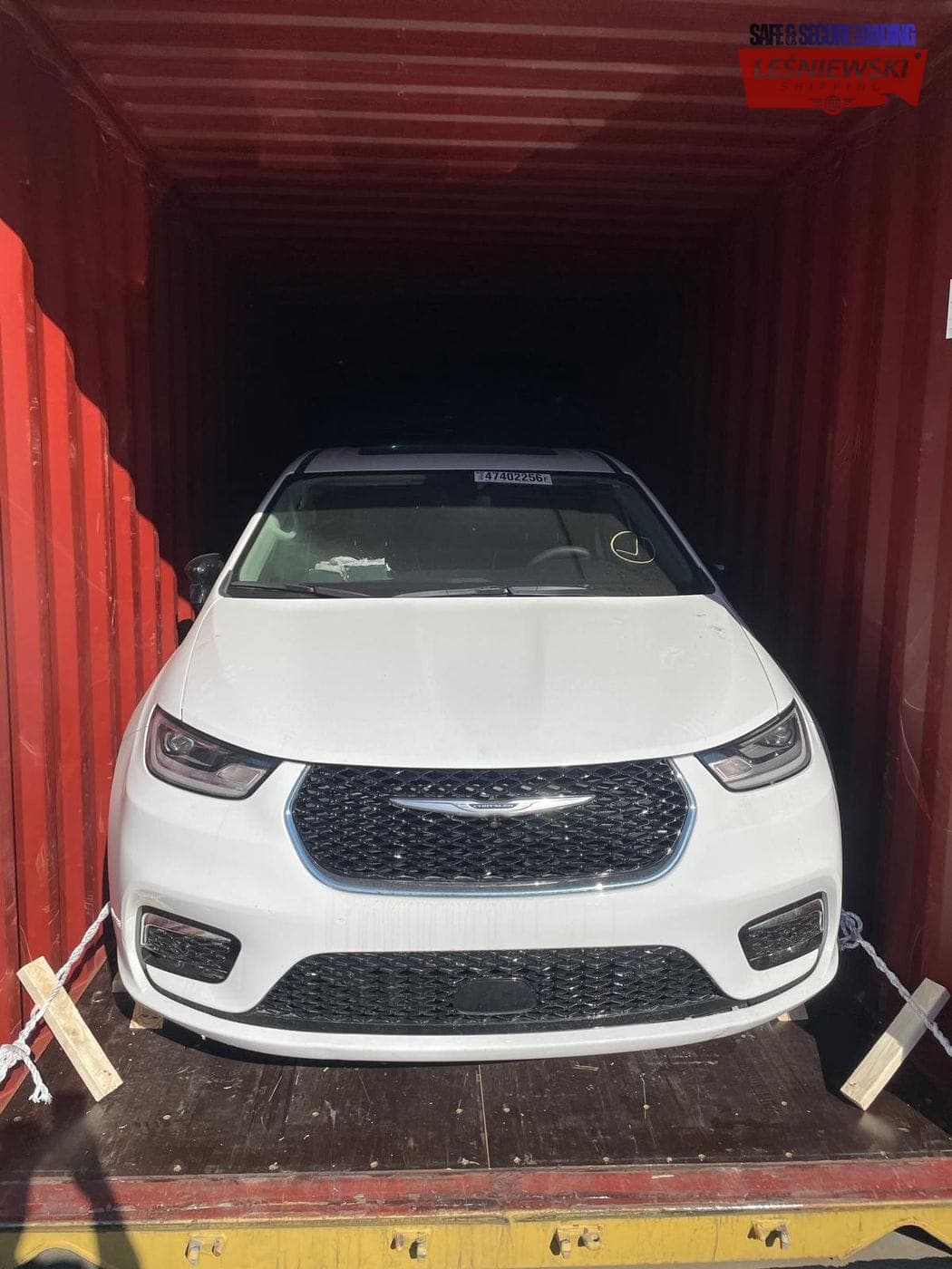 White Chrysler Pacifica minivan in a container — car shipping USA to Poland