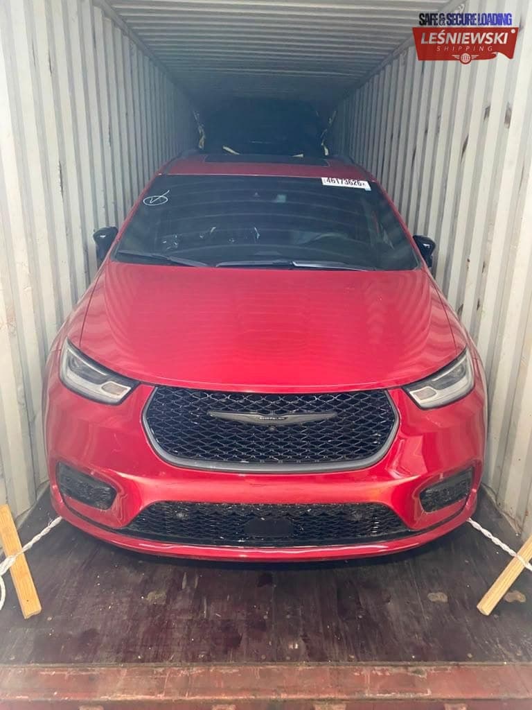 Red Chrysler Pacifica minivan in a container — car import from the USA