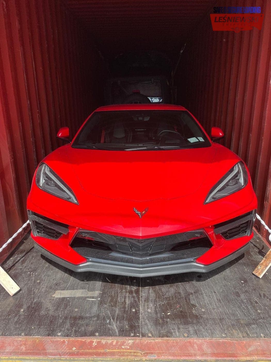 Loading a red Chevrolet Corvette into a container — car import from the USA