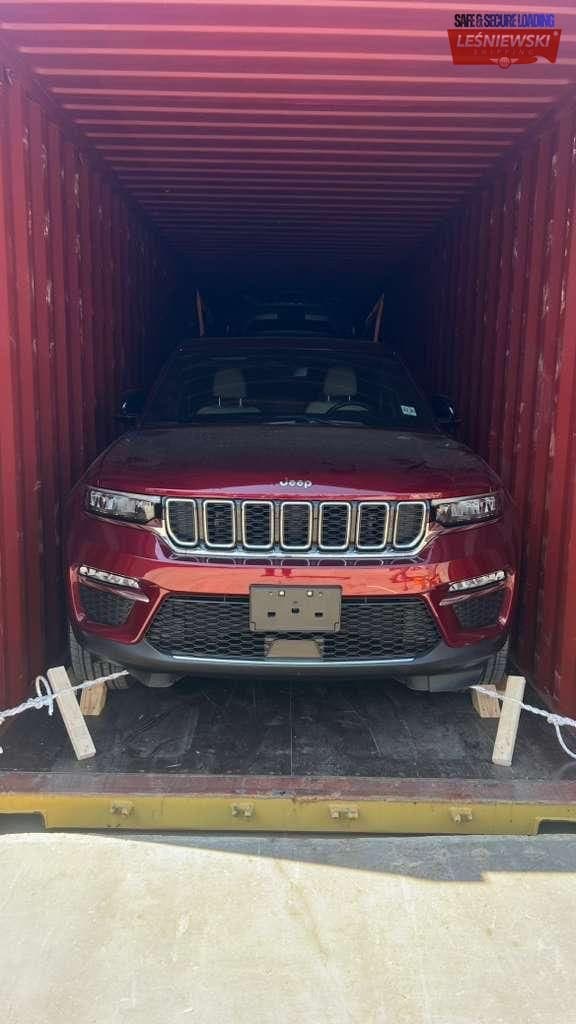 Red Jeep secured in a container — car shipping USA to Poland