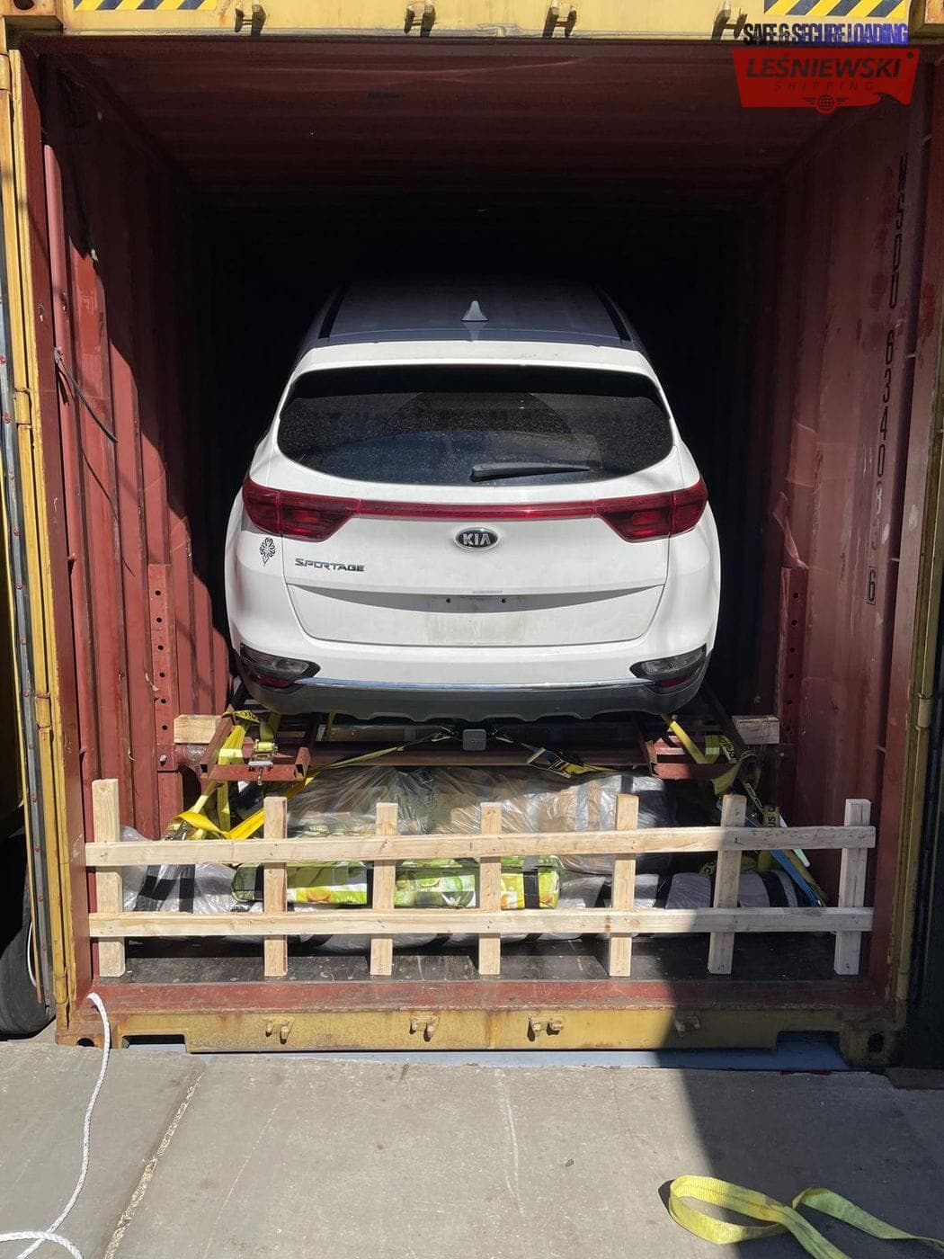 White Kia Sportage secured in a container — car import from the USA to Poland