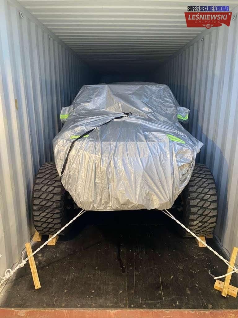 Covered off-road pickup secured in a container — car transport from the USA
